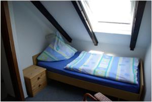 a small bed in a small room with a window at Haus Nordlicht in Helgoland