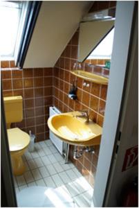 a bathroom with a yellow sink and a toilet at Haus Nordlicht in Helgoland
