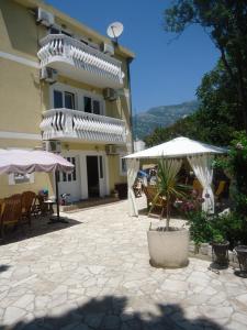 a patio with chairs and umbrellas in front of a building at Apartments Beba Zalad in Sutomore