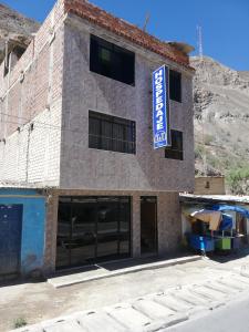 a building with a sign on the side of it at Hospedaje T&T in Churín