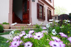 un jardín con flores rosas frente a una casa en YundAntik Cunda Konaklari, en Ayvalık