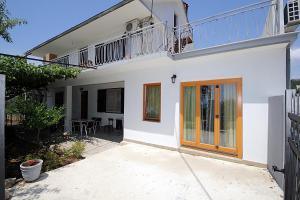 a white house with a balcony and a patio at Apartments Mirko in Ulcinj