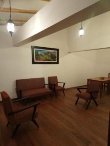 a waiting room with chairs and tables and a painting on the wall at Qali Samanawasi in Huaro