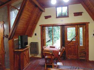 sala de estar con puerta y TV en Alpina Cabañas en Mar del Plata