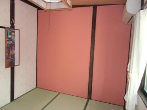 a room with a red wall at Kanazawa Share House GAOoo in Kanazawa