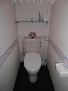 Kanazawa Share House GAOoo في كانازاوا: حمام صغير مع مرحاض أبيض عليه زهور