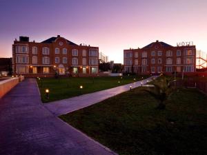 a large building with lights on the grass in front at Exe Zarzuela Park in Madrid
