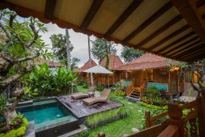 a backyard with a swimming pool and a house at Kakul Villas & Suites in Ubud