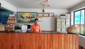 a man is standing at a counter in a office at Apex Koh Kong Hotel in Koh Kong
