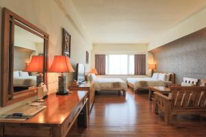 Pokój hotelowy z dużym lustrem i sypialnią w obiekcie Yentai Hotel w mieście Magong