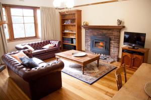 a living room with two couches and a fireplace at The Pear Cottage in Nubeena