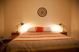 a bedroom with a bed with two lamps on it at The Pear Cottage in Nubeena