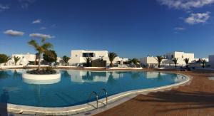 a large swimming pool in a resort with white buildings at Casa Sol Azul in Puerto Calero