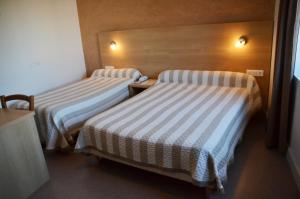 A bed or beds in a room at Hôtel de France
