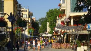 eine Gruppe von Menschen, die eine Straße mit Gebäuden entlanggehen in der Unterkunft Apartament Bogoridi in Burgas City