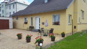 a patio with a table and flowers in front of a house at Apartment Věra in Lipova Lazne