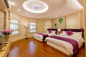 1 Schlafzimmer mit 2 Betten und lila Kissen in der Unterkunft Hliweng B&B in Yilan