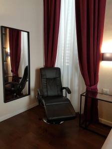 una sedia nera seduta in una stanza con specchio di 1suite firenze a Firenze