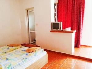 a bedroom with a bed and a tv on a wall at Guest House Bogat-Beden in Ravda