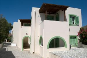 a white building with green doors and windows at Naxos olive & home in Engares