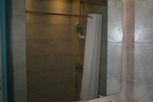 ein Bad mit einer Dusche und einem Spiegel in der Unterkunft Thalassa Apartment in Kallirákhi