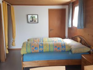 a bedroom with a bed with a blue comforter at Ferienstudio Familie Fässler-Dörig in Appenzell