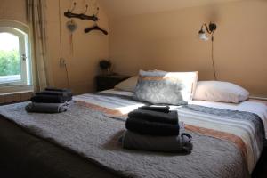 a bedroom with a bed with piles of towels on it at B&B Buitenwaard in Oosterhout