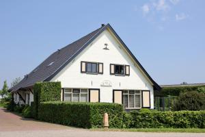 une maison blanche avec un toit noir dans l'établissement B&B Buitenwaard, à Oosterhout