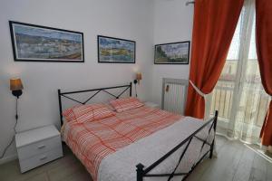 ピッツォにあるSan Giorgio by PizzoApartmentsのベッドルーム1室(赤いカーテンと窓付きのベッド1台付)