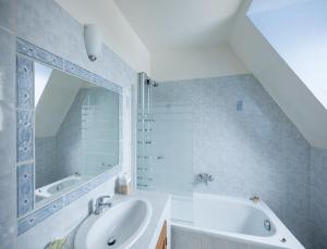 W łazience znajduje się umywalka, wanna i lustro. w obiekcie Château du Jard w mieście Chaumont-en-Vexin