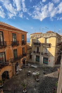 a group of buildings with tables and chairs in a courtyard at San Giorgio by PizzoApartments in Pizzo