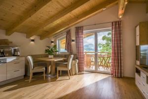 a kitchen and dining room with a table and chairs at Z`Aglers Ferienwohnungen in Oberau