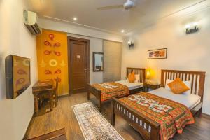 a hotel room with two beds and a television at Tree of Life Bed & Breakfast in New Delhi