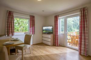ein Wohnzimmer mit einem Esstisch und einem TV in der Unterkunft Z`Aglers Ferienwohnungen in Oberau