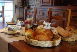a table topped with a basket of bread and pastries at Ti Ar Bugale in Huelgoat +31 photos