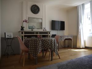 una sala da pranzo con tavolo, sedie e TV di Albert 1er a La Rochelle