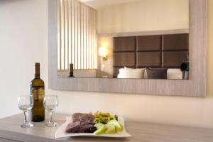 a table with a plate of food and a bottle of wine at Porto Demo Hotel in Agios Georgios Pagon