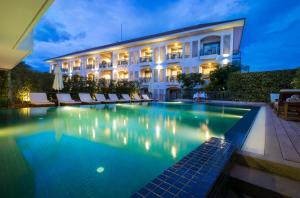 a hotel with a swimming pool in front of a building at Damrei Residence & Spa in Siem Reap