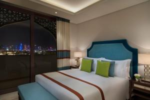 Rúm í herbergi á Al Najada Doha Hotel Apartments by Oaks