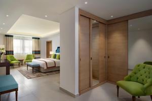 Rúm í herbergi á Al Najada Doha Hotel Apartments by Oaks