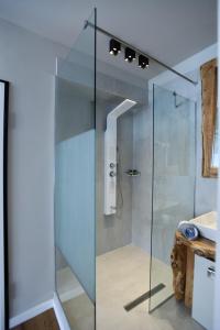 a glass shower in a bathroom with a sink at Magnifique Luxury Suites in Thessaloniki