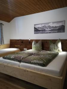 um quarto com uma cama grande e uma cabeceira em madeira em Altböckhof em Schlitters