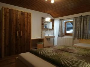um quarto com uma cama, um lavatório e uma janela em Altböckhof em Schlitters