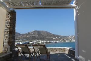 eine Terrasse mit Stühlen und Meerblick in der Unterkunft Akrotiraki Apartments in Platis Gialos Sifnos