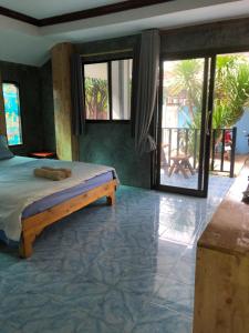 a bedroom with a bed and a view of a patio at Poopreaw Koh Larn in Ko Larn