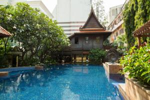 a swimming pool in front of a building at The Rose Residence, Bangkok in Bangkok