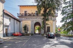 a building with an archway and cars parked in a parking lot at B&B Beata Solitudo in Agerola