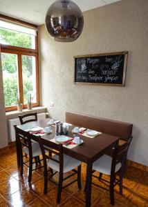 a dining room with a table and chairs and a sign at Hotel Am Rittergut in Frankenberg