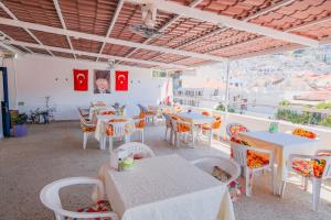 ein Restaurant mit Tischen und Stühlen und Aussicht in der Unterkunft Saray Hotel in Kaş