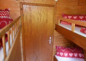 eine Holztür in einem Zimmer mit 2 Etagenbetten in der Unterkunft Schwammerlhütte in Krispl